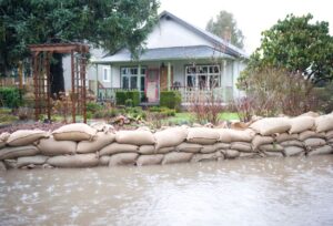 Des sacs de sable forment une protection anti inondation devant une maison, empêchant l'eau de pénétrer dans la propriété lors d'une crue.